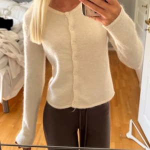 Krämvit stickad kofta med knappar - Supermysig krämvit stickad kofta med rund hals och långa ärmar från ginatricot, säljs ej längre på hemsidan. Använd fåtal gånger💕