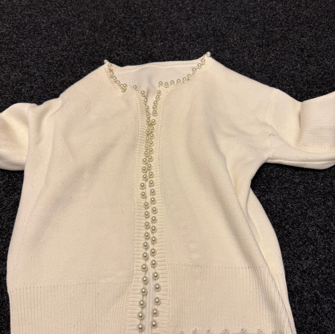 Vit kofta med pärldetaljer