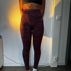 Vinröda camo leggings från Gymshark - Snygga vinröda leggings från Gymshark med camo-mönster och hög midja. Använt ett fåtal gånger, säljer då jag inte använder dom längre.