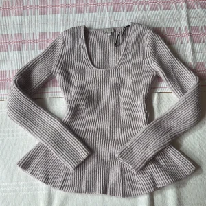  lila ribbad stickad tröja H&M - Säljer en  lila ( syns inte riktigt på bilden) stickad tröja från H&M i storlek S. Tröjan  har ett ribbat mönster, rundad halsringning och långa armar.