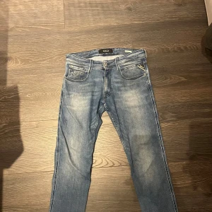 Replay Anbass jeans blå storlek 31 - Snygga Replay Anbass jeans i ljus blå tvätt med diskreta slitningar. Modellen är anbass. Jeansen är tillverkade i mjukt denim-material och har detaljerade sömmar på bakfickorna. Hör av dig vid frågor eller funderingar. 