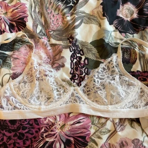 Vit spetsbh från Lounge - Säljer en vit bralette från Lounge med vacker spets och tunna axelband. Aldrig använd.