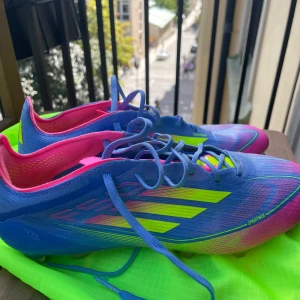 Adidas F50 elite helt oanvända pris kan diskuteras. - Säljer ett par Adidas fotbollsskor i en riktigt fet färgkombo med blått, neon-gult och rosa. Skorna har snörning, låg profil och är gjorda i syntetmaterial med ventilerande insida. Perfekt för dig som vill sticka ut på planen. Medföljer en neon-grön skopåse.