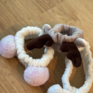 Band att ha vid ansiktstvätt o sminkning   - Supergulliga diadem i mjuk plysch med bruna renhorn och stora fluffiga bollar i ljusrosa och vitt. är stretchigt och sitter bekvämt på huvudet. En av dessa har släppt lite i en söm men ni får den på köpet. Lätt att laga.