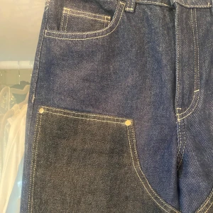 Blå jeans flerfärgade - Unika blå jeans med kontrasterande detaljer. Raka ben och tydliga vita sömmar. 