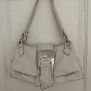 Vit vintage axelväska -  vit axelväska med silverfärgade detaljer.. 