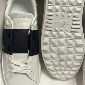 Valentino Garavani vita sneakers storlek 42 - Snygga vita sneakers från Valentino Garavani med bred svart rem över ovansidan. Skorna har rund tå, platt sula med mönstrad undersida och klassisk snörning. Tillverkade i slätt skinn för en clean och lyxig look. Perfekta för dig som gillar stilrena designer.  Använda ett par gånger