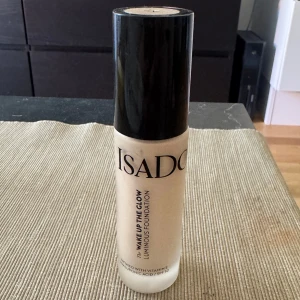 Isadora Wake Up The Glow Foundation - Foundation från Isadora i nyansen 1N, perfekt för en naturlig och fräsch look. Kommer i en stilren glasflaska med svart lock. Innehåller vitamin E, hyaluronsyra och har SPF 50 för extra skydd. Ger ett glowigt och jämnt resultat.