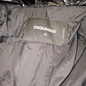 Svart pufferjacka från Dsquared2 - Säljer en exklusiv och eftertraktad Dsquared2 dunjacka i glänsande svart. Modell: Patch Logo Shiny Black Down Jacket Storlek: 52 (passar ca L/XL beroende på passform)  ✅ Äkta Dsquared2 ✅ Nypris ca 4-5000 Kr ✅ Mycket bra skick ✅ Klassisk DSQ2-logga på bröstet ✅ Varm och bekväm dunjacka – perfekt för höst och vinter  💵 Pris: 2 800 kr (eller bud) 🚚 Kan skickas mot frakt eller hämtas på plats