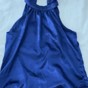 Blå siden linnetopp med halterneck - Supersnygg blå linnetopp i glansigt sidenmaterial med halterneck.  Från shein men tror inte man märker det så mycket. 