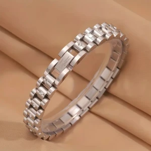 Silverfärgat armband med stenar - Stilrent armband i silverfärgad metall med en länkdesign och små gnistrande stenar infällda i flera av länkarna. Armbandet har en modern och clean look, perfekt för dig som gillar detaljer och vill ha något som sticker ut lite extra.