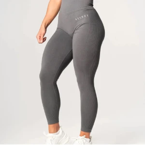 Grå leggings från Relode - Snygga grå leggings från Relode med ribbad design. De är högmidjade och har en tight passform som framhäver figuren. Perfekta för träning eller en aktiv vardag. Finns ej kvar på hemsidan