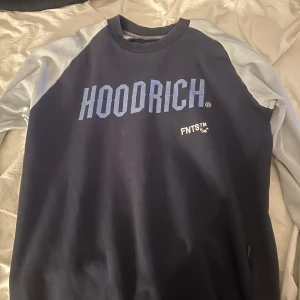 Mörkblå och ljusblå tröja från Hoodrich - Säljer en mörk och ljusblå tröja från Hoodrich med texttryck både fram och bak. Tröjan har långa ärmar och en rund halsringning. Använd några gånger men i bra skick. 