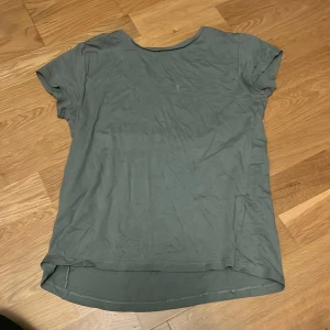 Grön t-shirt från H&M - Säljer en enkel och stilren grön t-shirt från H&M. Den är tillverkad i ekologisk bomull och har en normal passform med korta ärmar. Den är skrynklig på bilden men det borde gå bort om man stryker den.💚