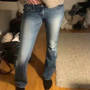 Blå bootcut jeans - Snygga blå bootcut jeans. De har en knapp och dragkedja framtill och en lätt tvättad look som ger en avslappnad stil. Perfekta för en casual outfit. Säljer pågrund av att dem ej kommer till användning. 