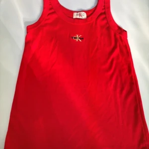 Röd linnetopp från Calvin Klein - Snygg röd linnetopp från Calvin Klein med deras ikoniska logga på bröstet. Perfekt för varma sommardagar eller som ett lager under en jacka. Enkel och stilren design som passar till det mesta.