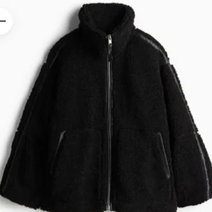 Teddyjacka H&M stl S - Mysig svart teddyjacka med dragkedja framtill. Jackan har en hög krage och två fickor på sidorna. Perfekt för kyliga dagar när du vill hålla dig varm och stilren.