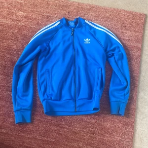 Blå träningsjacka från Adidas - Säljer en snygg blå träningsjacka från Adidas. Storlek S. Mycket Bra skick