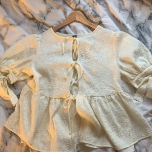 Söt knytbar blus från Shein - Jätte söt blus från Shein som aldrig kommer till användning, lite stor i storleken men fin på ändå, har 3 snören att knyta fram och två rosetter i ärmen. Har en fin volang och söta blommor i tyget. Köpte för 189kr säljer för 100kr