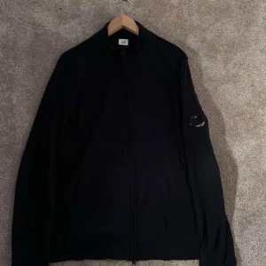 Svart jacka från C.P. Company - Säljer en stilren marinblå kofta från C.P. Company med dragkedja. Koftan är i storlek M. Alltid snabba svar! 