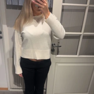 Vit stickad tröja - Säljer en stilren vit stickad tröja med långa ärmar och ribbade detaljer vid ärmslut och nederkant. Perfekt för en mysig och avslappnad look. Passar bra till både jeans och kjol.