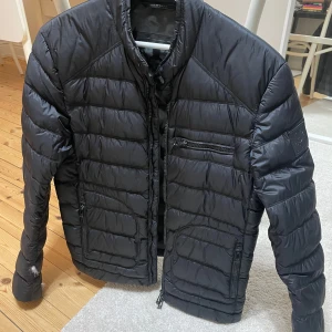 Belstaff Dunjacka - Belstaff jacka i dun med biker stil.  Jackan är fint bevarad förutom små hål som släpper dun - se bilder. Det går att laga eller tejpa för men jag har inte haft tid.  Nypris: 3899kr