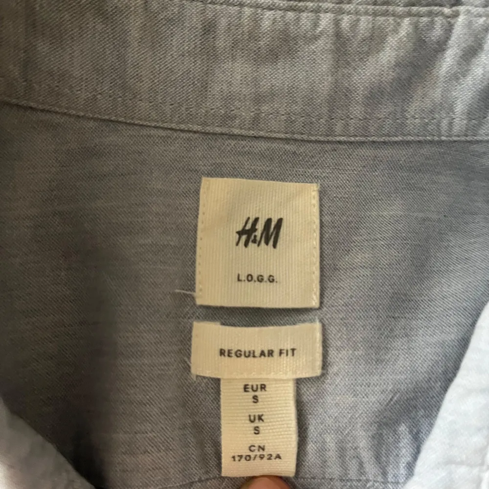 Säljer en stilren blå skjorta från H&M med normal passform. Skjortan har långa ärmar och knappar framtill samt på ärmsluten. Perfekt för en avslappnad men ändå snygg look.. Paidat.