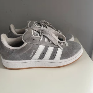 Grå Adidas Campus sneakers - Skit snygga gråa adidas campus! Köpte förra våren men användes bara under ungefär 2-3 månader! Köpte på merch Sweden och på sista bilden ser du även bevis på att de är äkta! Storlek 38 och 2/3 men passar mig som normal har 38 eller 39 .Nypris: 1500kr. Säljer för 800kr