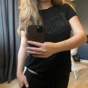 Svart t-shirt med fransdetalj - T-shirt med fransar. Storlek XS. Använd fåtal gånger. 💥