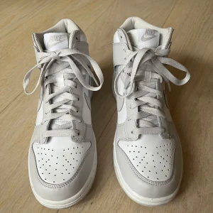Nike Dunk High Vast Grey  - Nike Dunks endast använda 1 gång då de är något små i storleken för mig. Har en liten repa på sidan av skon. Annars i väldigt bra skick. Köpta för 1799kr av We got them.