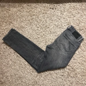 Jack and Jones Slim Straight Tim grå jeans - Snygga grå jeans med slim straight passform. Jeansen har en mörkgrå tvätt med lätt slitning och raka ben. Mycket bra skick, inga anmärkningar. Storlek W32, men mått kan såklart skickas vid osäkerhet. Kan mötas sthlm, annars postas dem samma dag som köp eller dagen därpå🙌💯