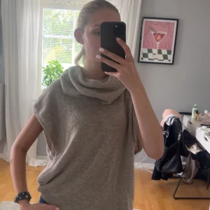 Beige stickad ärmlös polotröja - Supermysig beige stickad polotröja utan ärmar och med bred, slouchy krage. Perfekt att slänga över en långärmad eller bära som den är. Snygg loose fit och riktigt chill vibe. Perfekt höst tröja!💕