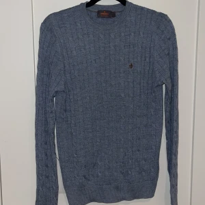 Blå kabelstickad tröja från Morris - Säljer en blå kabelstickad tröja från Morris i 100% merinoull. Skick 8/10