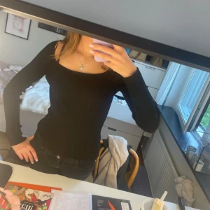 Svart långärmad tröja - Tröjan har en tight passform och är perfekt att styla med jeans eller kjol. Enkel och stilren design som funkar året runt. Jätte snygg att ha på tex fester eftersom den är lite mer uppklädd