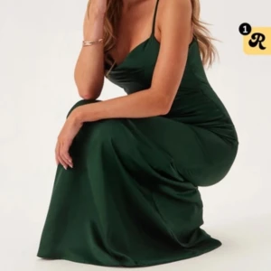 Mörkgrön långklänning med öppen rygg - säljer min snygga mörkgrön balklänning med smala axelband och djup öppen rygg. Klänningen har en elegant, figurnära passform och är tillverkad i ett glansigt material som ger en lyxig känsla. Klänningen har även ett band längst upp vid nacken🩷🩷säljer pågrund av ingen användning. Klänningen är använd 1 gång. Klänningen är uppsydd och passar i längden på någon som är ca 160cm