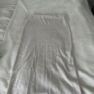 Beige långkjol från Zara - Säljer en stilren beige långkjol från Zara i storlek S. Kjolen har en rak och tight passform med mjukt stickat material som känns skönt mot huden. Perfekt för dig som gillar minimalistisk och clean look. Tar frakt