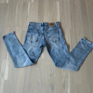 Replay ljusblå jeans straight fit - Säljer ett par ljusblå jeans från Replay med klassisk femficksdesign och snygga detaljer på bakfickorna. Jeansen har rak passform och normal midja, tillverkade i mjukt bomullsjeans. Perfekta för dig som gillar en clean och avslappnad look.
