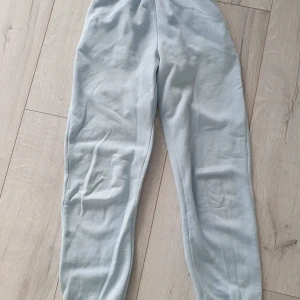 Ljusblå mjukisbyxor från Gina Tricot - Bekväma ljusblå mjukisbyxor från Gina Tricot, basically basics-kollektionen. De har resår i midjan, sidofickor och är gjorda i mjukt bomullsmaterial. Perfekta för chill dagar eller när du vill vara extra comfy.