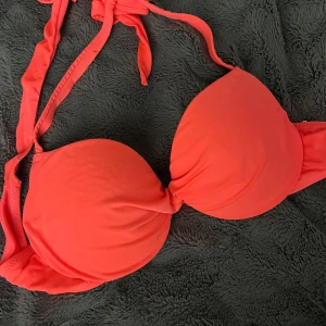 Korallrosa bikiniöverdel från H&M - Jättesnygg korallrosa bikiniöverdel från H&M med vadderade kupor och knyt i nacken. Bikinin har en enkel och stilren design utan mönster, perfekt för strandhäng. Materialet är mjukt och bekvämt. Vid frågor hör av dig!
