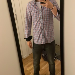 Rutig skjorta - Säljer en långärmad skjorta med rutigt mönster i blått, vitt och rött. . Perfekt för dig som gillar en soft stil. Inga defekter på skjortan förekommer. Pris kan diskuteras vid köp av bindel.