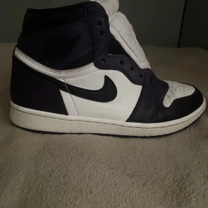 Nike Air Jordan 1 Retro High OG Court Purple - Säljer ett par Nike Air Jordan 1 Retro High OG i färgen Court Purple och vit. Skorna har en klassisk design med svart swoosh och snörning. Perfekta för sneakerheads som älskar en stilren look. Köpta för 4000. Använda men i hyfsat gott skick. Om fler bilder skicka pm. Står för frakten.