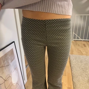 Mönstrade byxor - Snygga byxor med ett svartvitt mönster. De har en tight passform och är högmidjade, vilket ger en smickrande siluett. Perfekta för att ge din outfit en trendig touch.