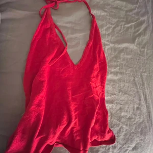 Röd axelbandslös topp - Snygg röd topp med axelbandslös design och v-ringning. Perfekt för en somrig dag eller en kväll ute. Topppen har en lätt och luftig känsla.❤️