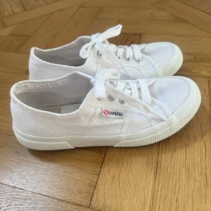 Vita sneakers från Superga - Säljer ett par klassiska vita sneakers från Superga i storlek 38. Använda 2 gånger