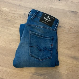 Blå jeans från Replay - Snygga blå jeans från Replay i modellen Anbass. De har en slim fit passform och klassisk femficksdesign. Perfekta för en stilren look. Skick 10/10. Längd 30 och midja 30. Skriv för frågor! Priset kan diskuteras vid snabb affär!