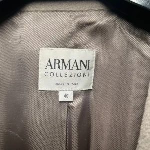 Beige kappa från Armani Collezioni - En mycket snygg vintage Armani Collezinoi kappa i storlek 38 varm men funkar även perfekt året om. Det står att storleken på jackan är 46 efter som de är italiensk storlek men de motsvarar 38