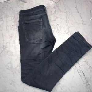 Mörkblå jeans från Nudie Jeans - Snygga mörkblå jeans från Nudie Jeans med en klassisk femficksdesign. De har en normal passform och är tillverkade i ett slitstarkt denimtyg. Perfekta för en stilren look.