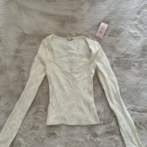 Vit topp från Nelly - Vit topp från nelly, aldrig använd. Långa ärmar och väldigt snygg i bysten
