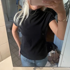Svart polotopp från Zara - Säljer en svart kortärmad polotopp från Zara. Passar utmärkt till både jeans och kjol. Storlek XL-32 är mer som en S/M skulle jag säga🖤