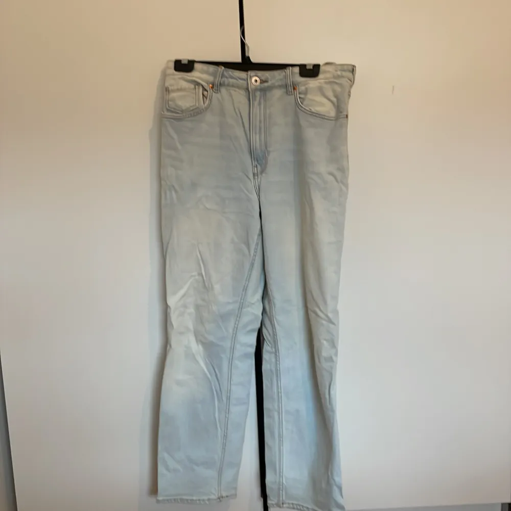 Säljer ett par ljusblå jeans från H&M. De har en klassisk femficksdesign och är tillverkade i ett mjukt denimtyg. Perfekta för en avslappnad stil.. Farkut & Housut.
